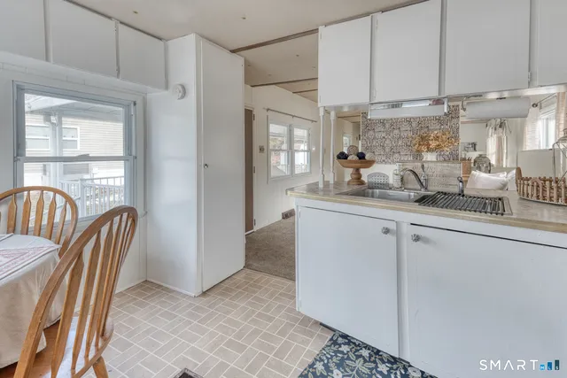 a kitchen with stainless steel appliances granite countertop a refrigerator a sink a stove and white cabinets