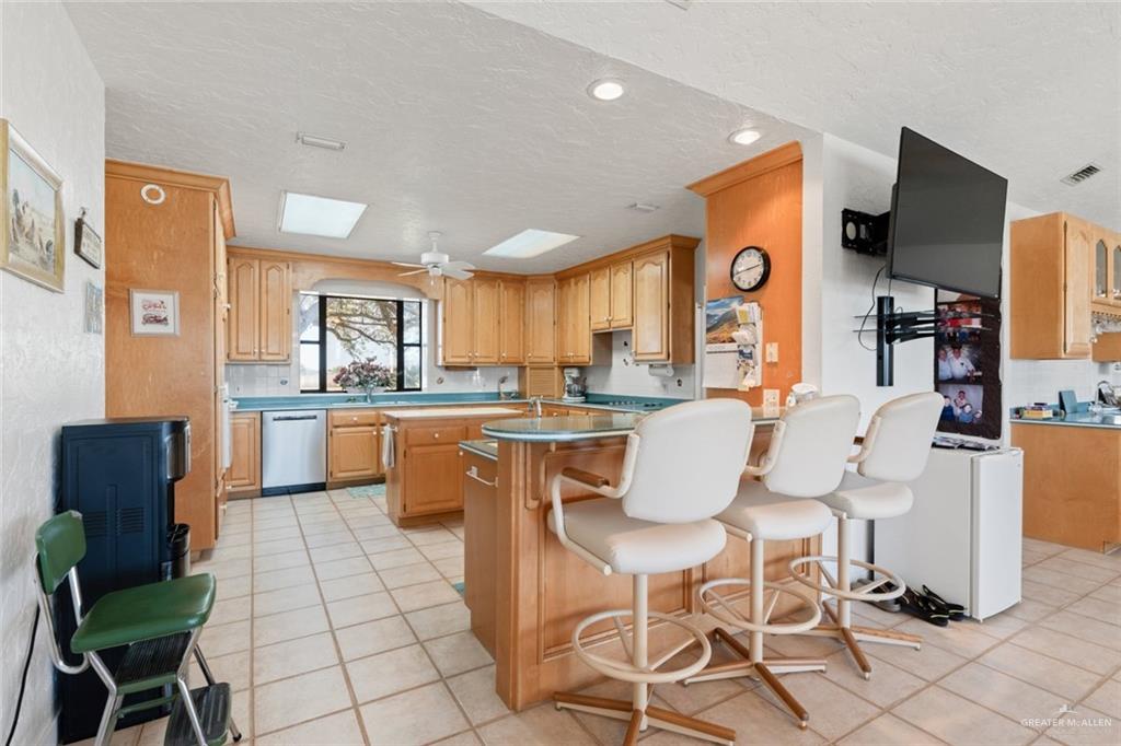 1420 West Estero Drive Progreso Lakes, TX 78596 - Photo 7 of 42 a dining hall with stainless steel appliances kitchen island granite countertop a dining table chairs and a refrigerator