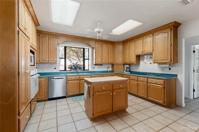 a kitchen with stainless steel appliances granite countertop a sink a stove counter space and cabinets