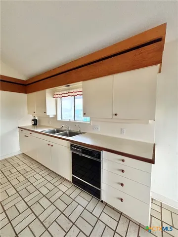 a kitchen with a sink cabinets and window