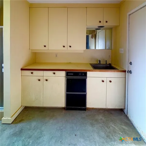 a large white kitchen with granite countertop a sink