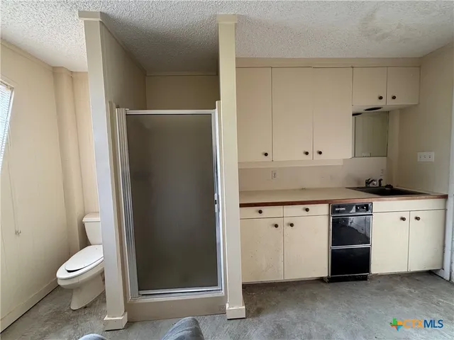 a view of a livingroom with kitchen space and window