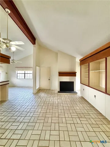 a view of an empty room with a fireplace and a window
