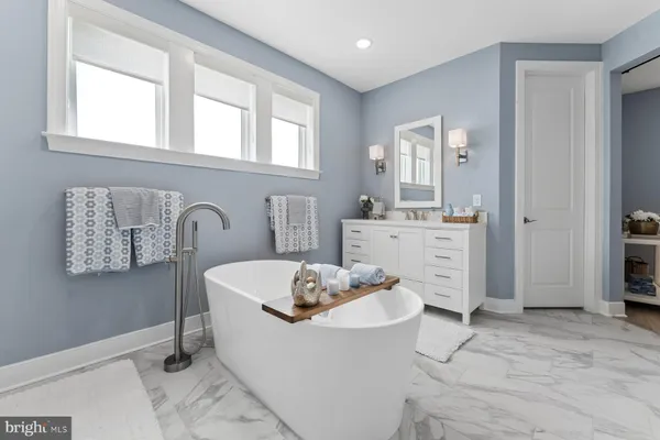 a bathroom with a tub sink and a mirror