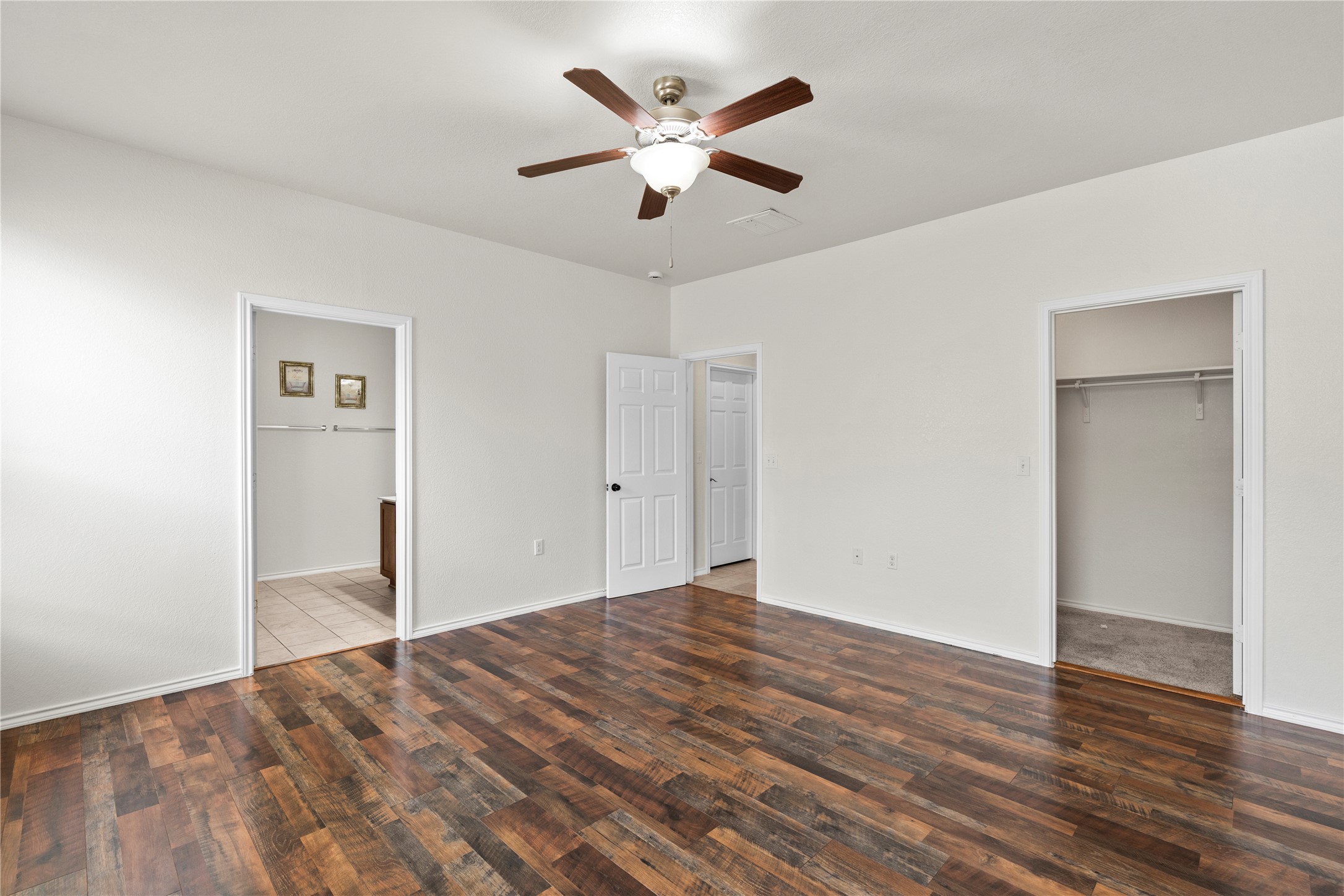 8613 Capitol View Drive Austin, TX 78747 - Photo 11 of 33 Rich wood plank flooring sets the tone for comfortable living in this well-appointed bedroom.