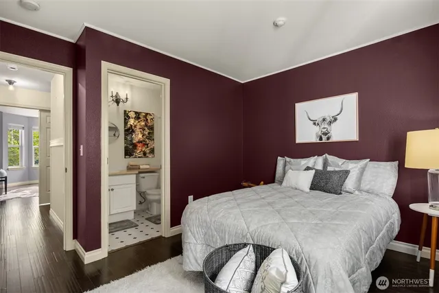 a bedroom with a bed and a painting on the wall