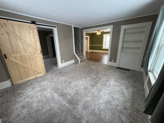 a view of an empty room with closet and window