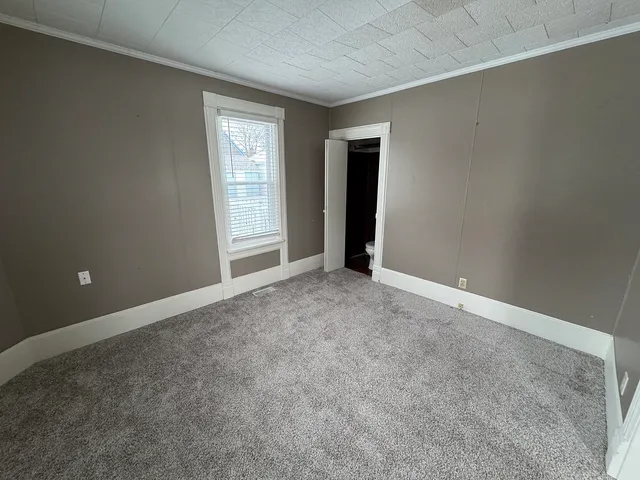 an empty room with windows and closet