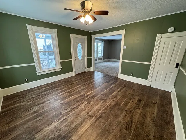 a view of a livingroom with wooden floor and a ceiling fan