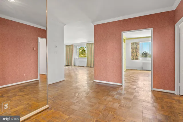 a view of a hallway with wooden floor and a living room