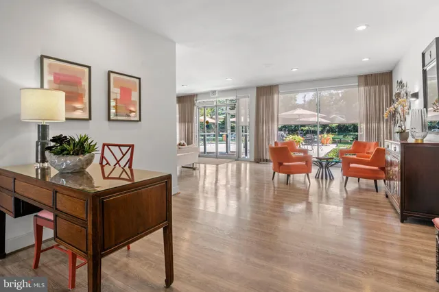 a living room with furniture a large window and wooden floor