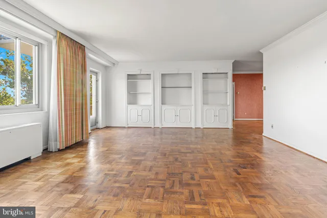 an empty room with windows and closet