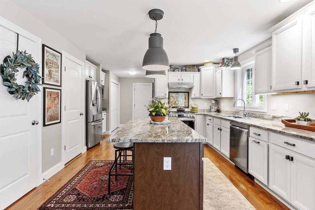 100 Platts Road Ashburnham, MA 01430 - Photo 6 of 42 a kitchen with stainless steel appliances granite countertop a refrigerator a sink dishwasher a stove and white cabinets with wooden floor