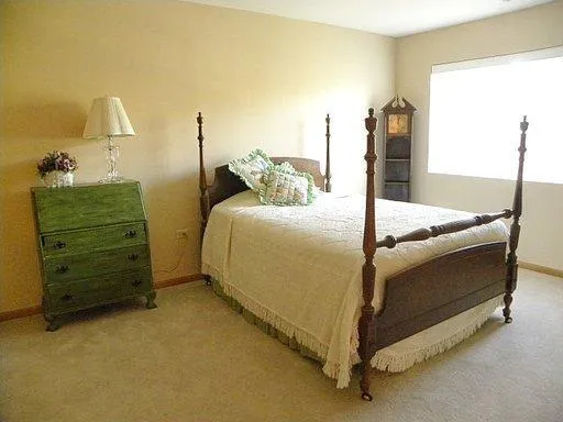 a bed sitting in a bedroom next to a lamp