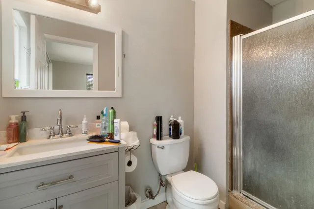 a bathroom with a toilet a sink a mirror and vanity