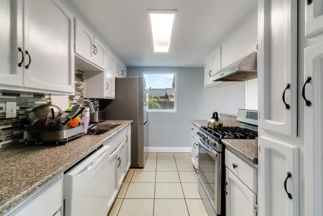 a kitchen with stainless steel appliances granite countertop a sink stove and cabinets