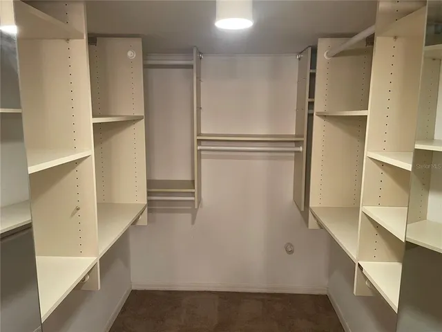 a view of walk in closet with empty racks