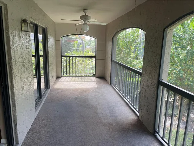 a view of an empty room with wooden floor and windows