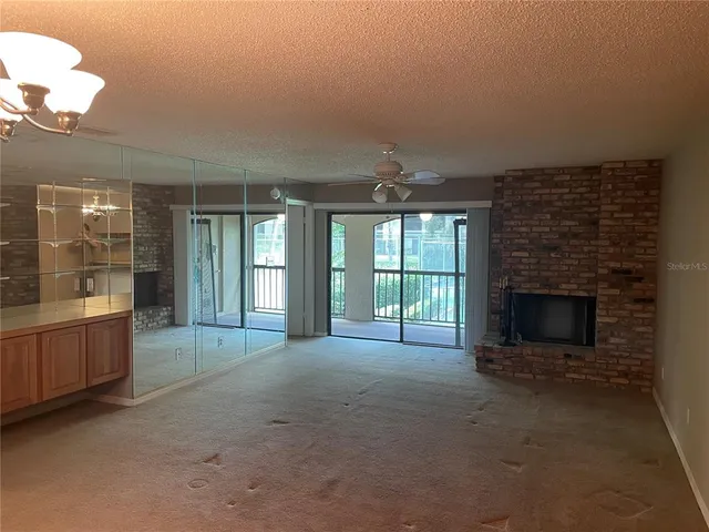 a view of an empty room with a fireplace and a window
