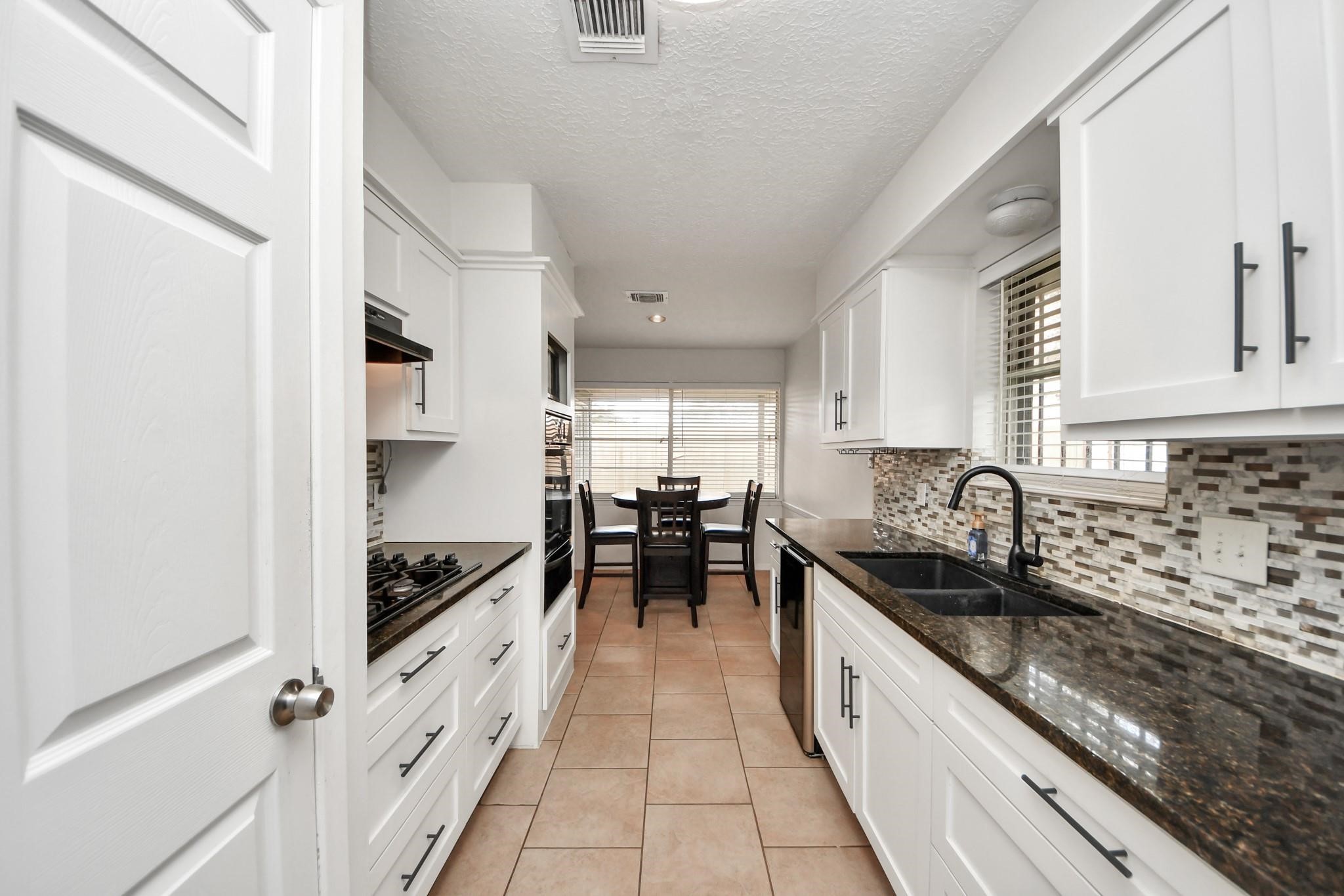 1415 Parry-Sound Pasadena, TX 77504 - Photo 11 of 34 a kitchen with granite countertop a sink stove and cabinets