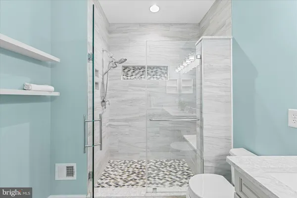 a bathroom with a toilet a sink and mirror