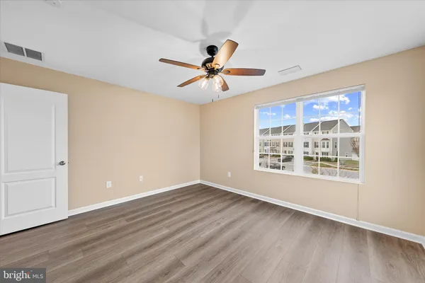 a view of a big room with wooden floor and a ceiling fan
