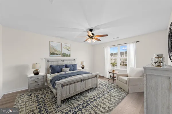 an empty room with wooden floor and ceiling fan