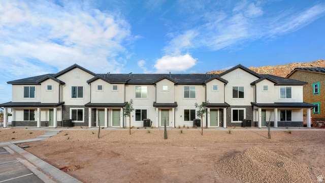 Traditional home with brick siding, stucco siding, and a porch