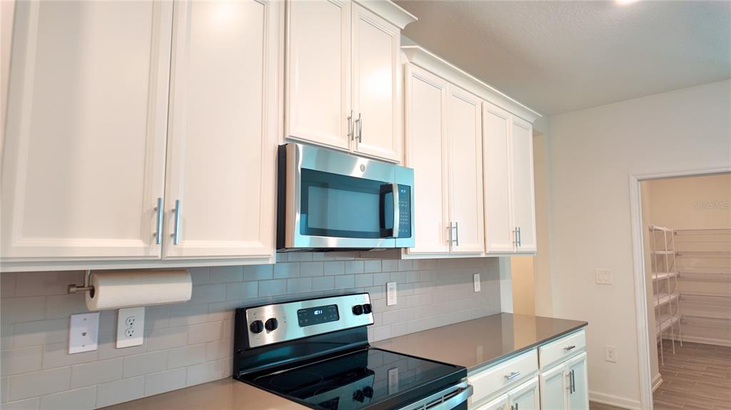 6366 Lakepine Street St. Cloud, FL 34771 - Photo 13 of 22 a kitchen with stainless steel appliances a stove and a microwave