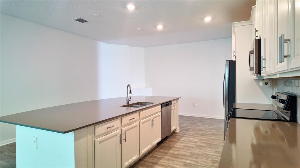 6366 Lakepine Street St. Cloud, FL 34771 - Photo 19 of 22 a kitchen with stainless steel appliances granite countertop a sink stove and refrigerator