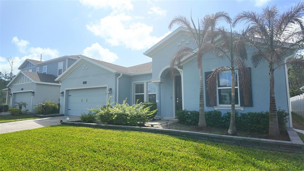 6366 Lakepine Street St. Cloud, FL 34771 - Photo 2 of 22 a view of a house with brick walls and a yard with plants