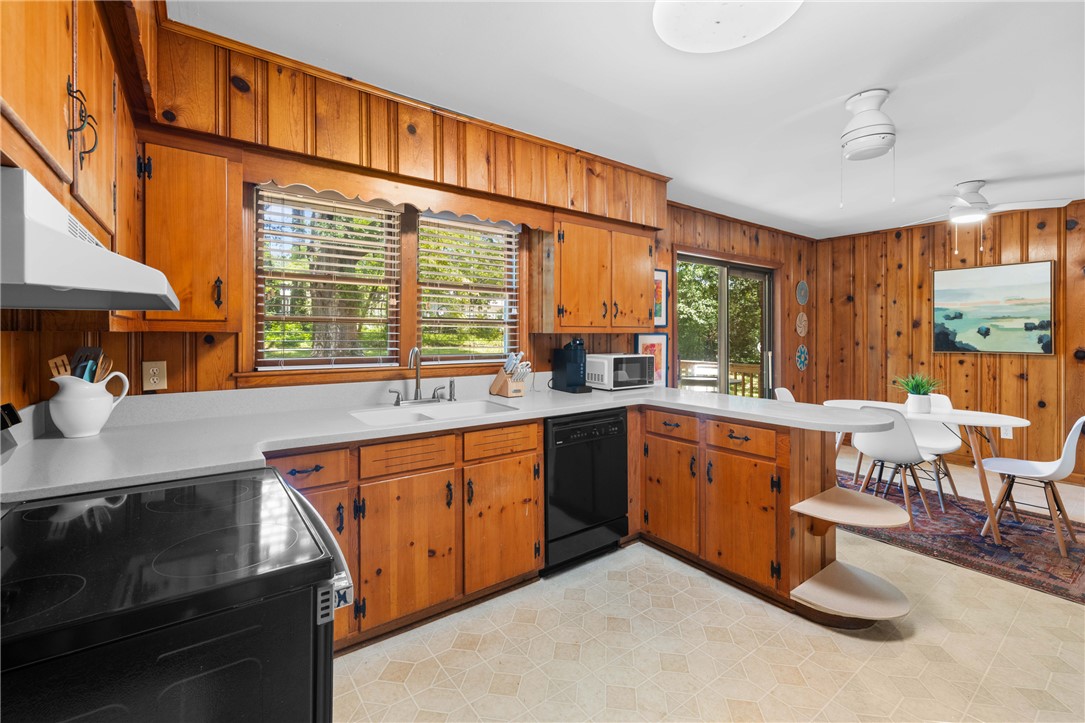 207 Brook Street Clemson, SC 29631 - Photo 15 of 39 A country-style kitchen offers plentiful cabinet storage and outdoor access, blending rustic charm with modern utility.
