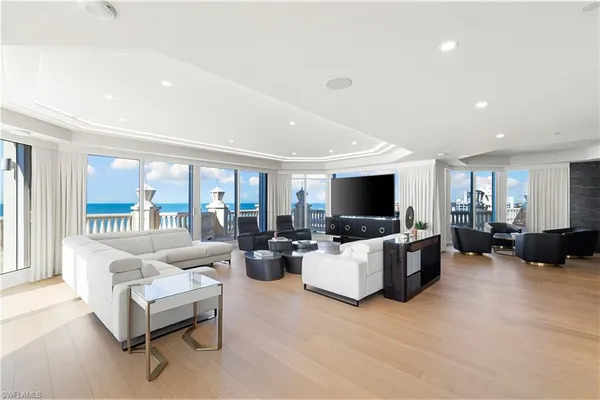 a living room with furniture flat screen tv and a large window