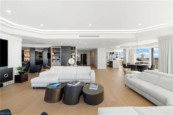 a living room with furniture a table and large window