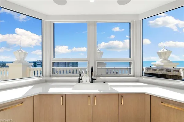 a view of a kitchen with granite countertop a sink and a large window