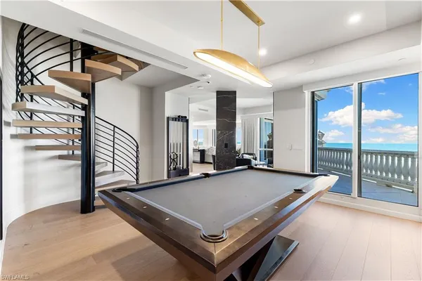a living room with a table a chandelier and flat screen tv