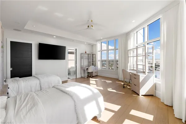 a bedroom with a bed window and a flat screen television
