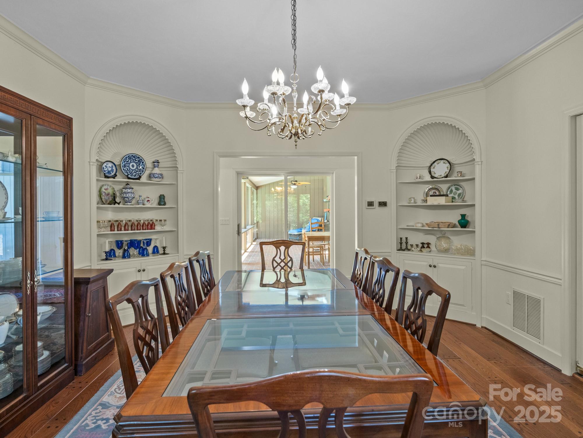 831 Hooper Creek Road Tryon, NC 28782 - Photo 15 of 48 a view of a dining room with furniture wooden floor and a chandelier