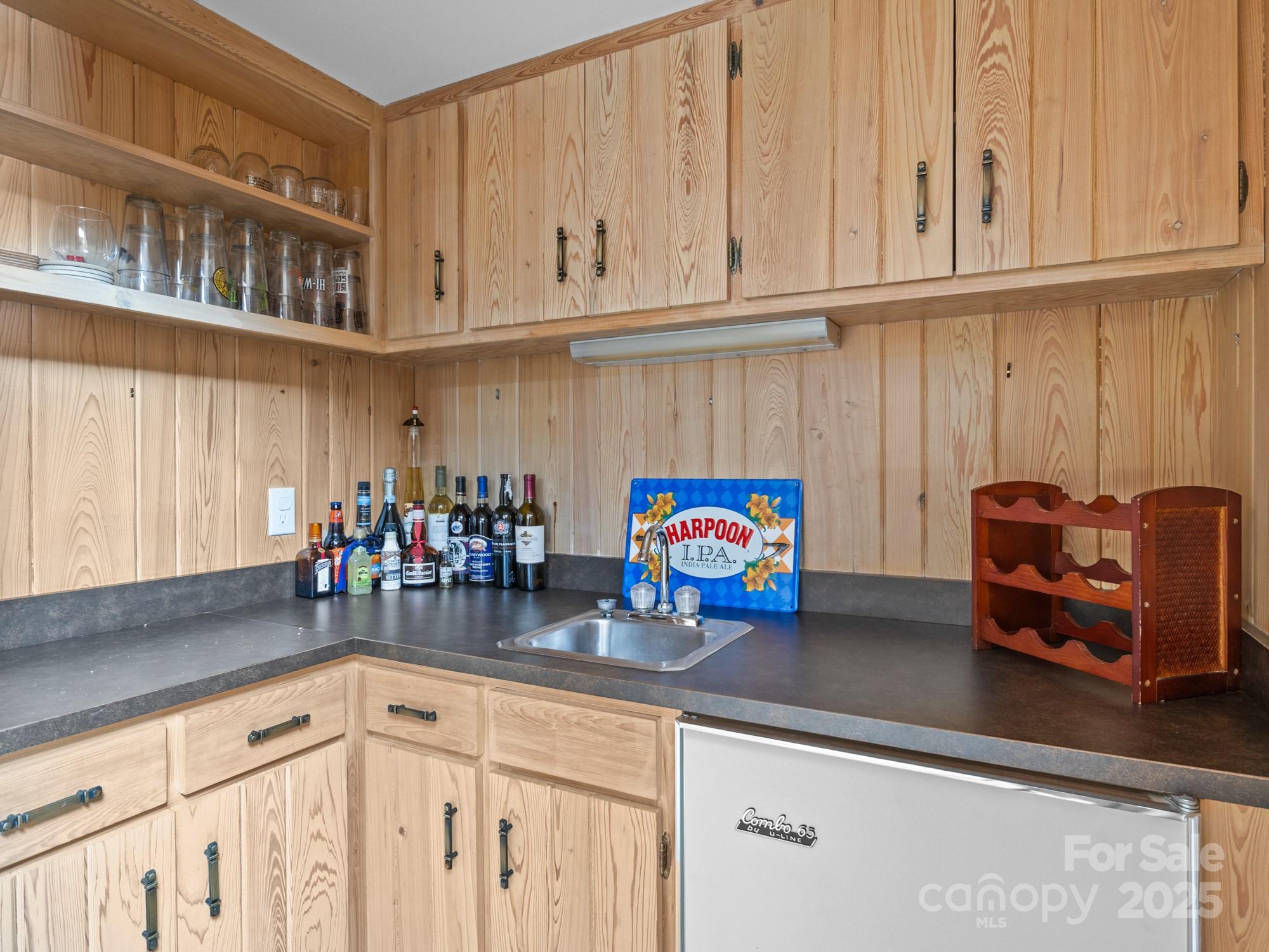 831 Hooper Creek Road Tryon, NC 28782 - Photo 32 of 48 a kitchen with stainless steel appliances granite countertop a sink dishwasher and cabinets with wooden floor