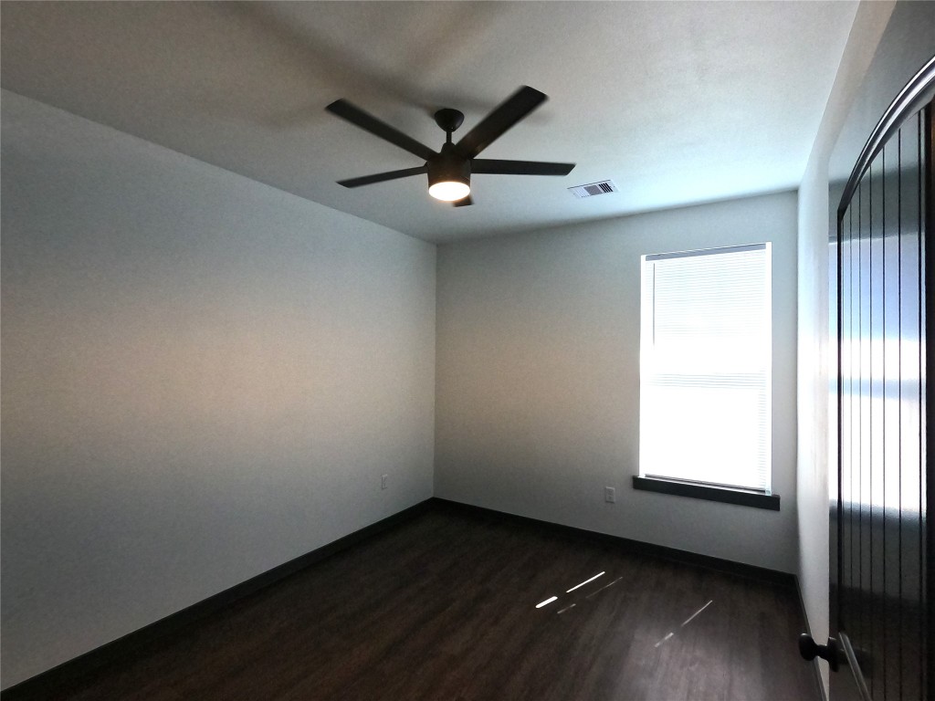 5334 Rapido Road Houston, TX 77033 - Photo 6 of 13 an empty room with wooden floor fan and windows