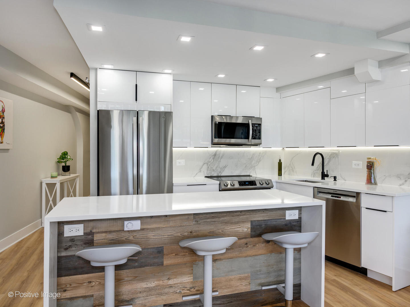 300 North State Street, Unit 5125 Chicago, IL 60654 - Photo 2 of 21 a kitchen with stainless steel appliances kitchen island granite countertop a sink and a stove top oven with wooden floor