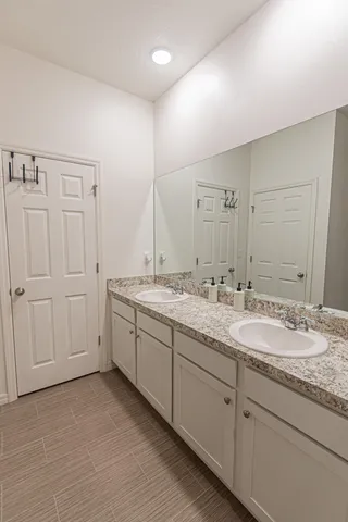 a spacious bathroom with a granite countertop sink and a mirror