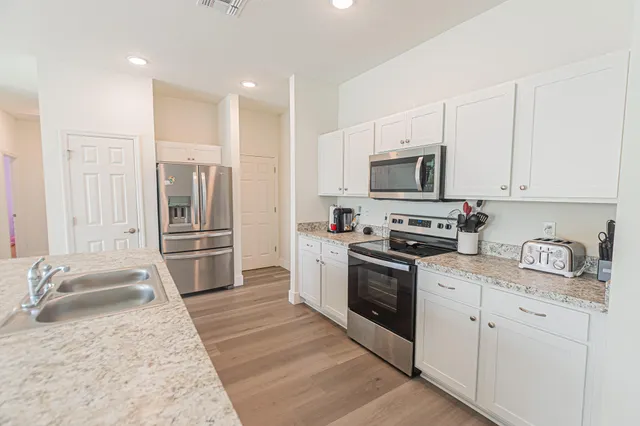 a kitchen with granite countertop a sink stove and refrigerator