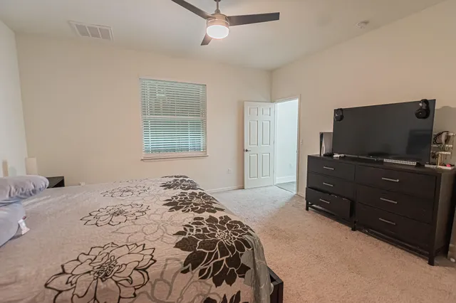 a bedroom with a bed and flat screen tv