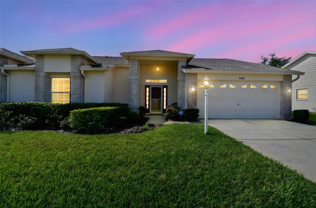 12202 Aaron Terrace Trinity, FL 34655 - Photo 2 of 41 a front view of a house with a yard and garage