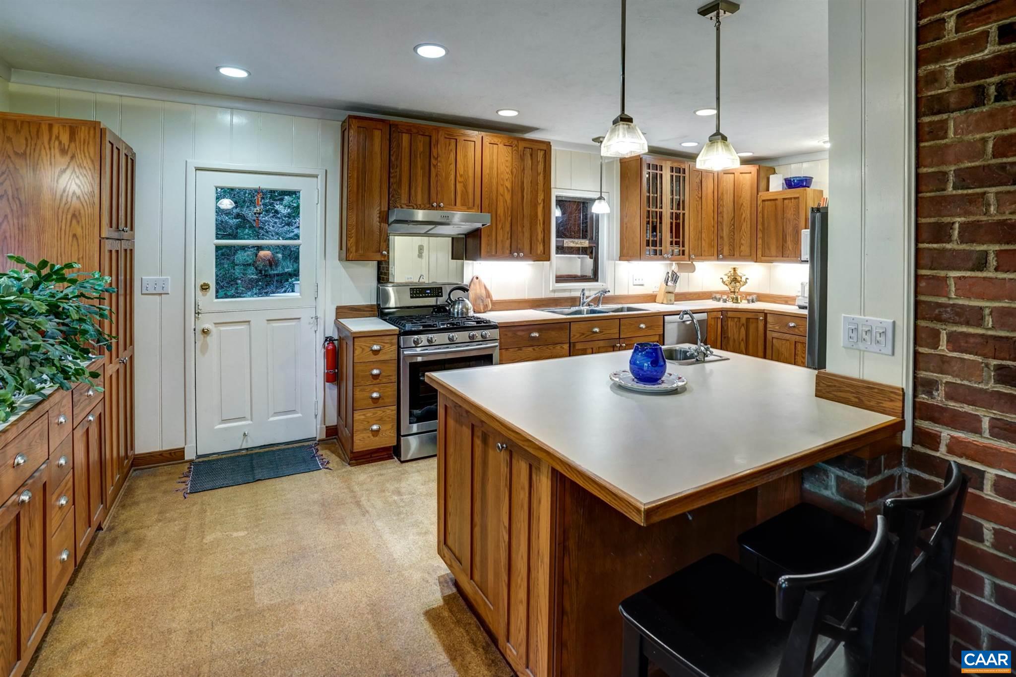 2006 Meadowbrook Road Charlottesville, VA 22903 - Photo 17 of 43 a kitchen with stainless steel appliances granite countertop a stove a refrigerator a oven a sink a dining table and chairs with wooden floor