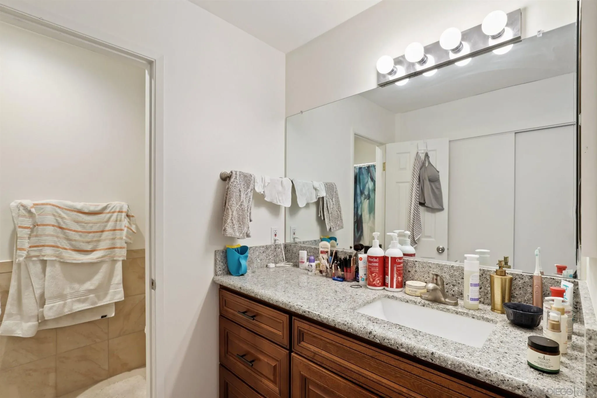 1633 Thomas Avenue San Diego, CA 92109 - Photo 11 of 48 a bathroom with double vanity sinks and a mirror