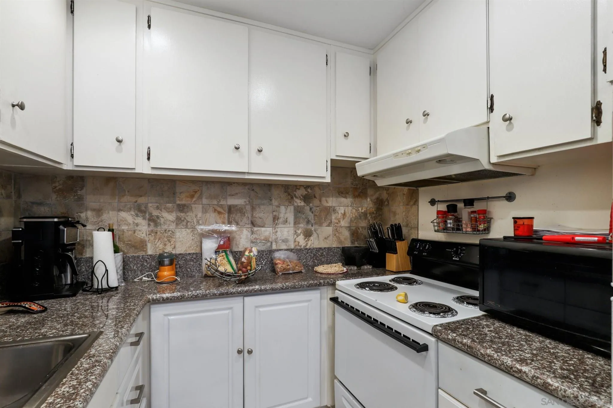 1633 Thomas Avenue San Diego, CA 92109 - Photo 16 of 48 a kitchen with stainless steel appliances granite countertop a stove and a white cabinets