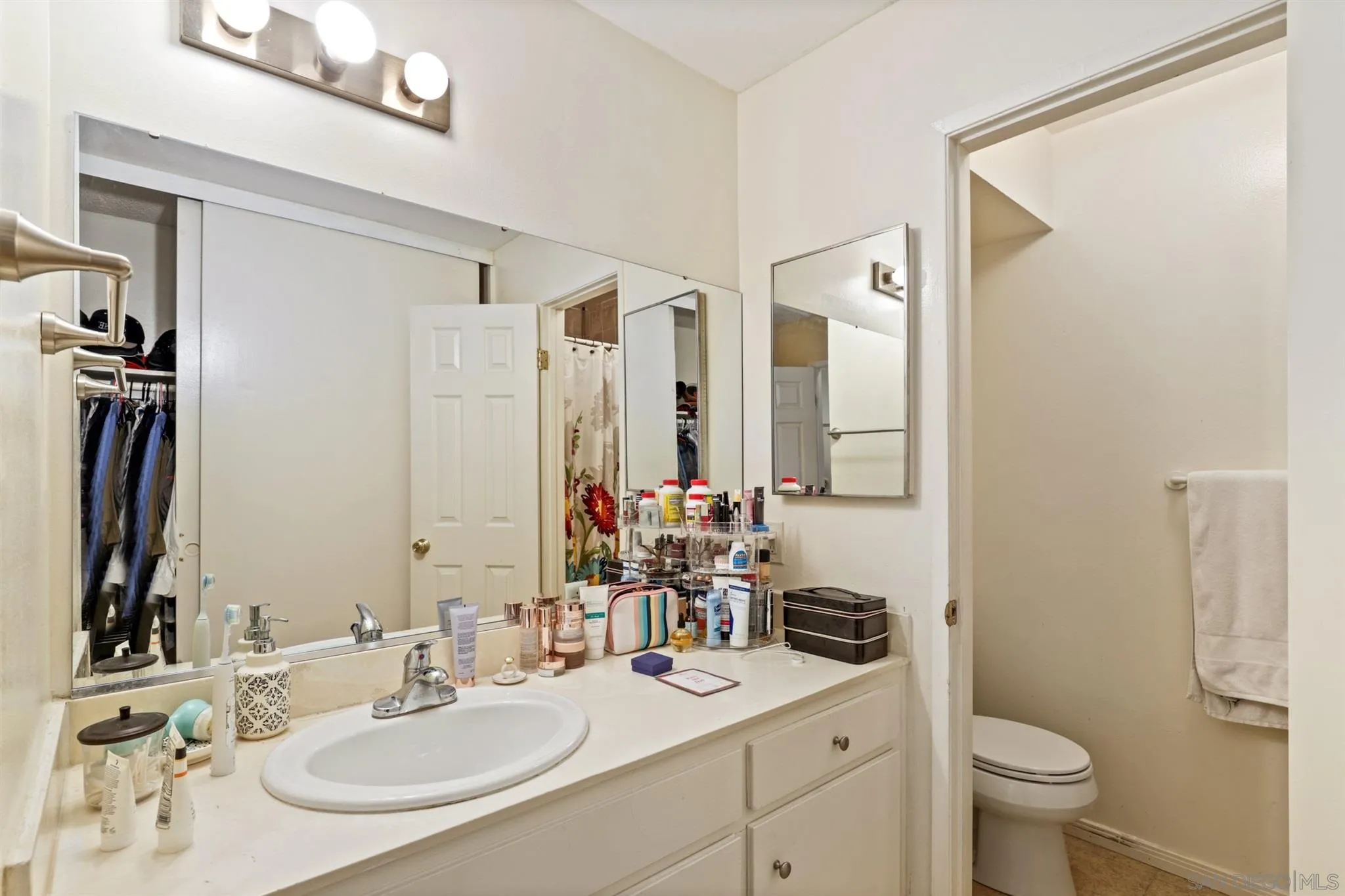 1633 Thomas Avenue San Diego, CA 92109 - Photo 21 of 48 a bathroom with a sink and a mirror with toilet
