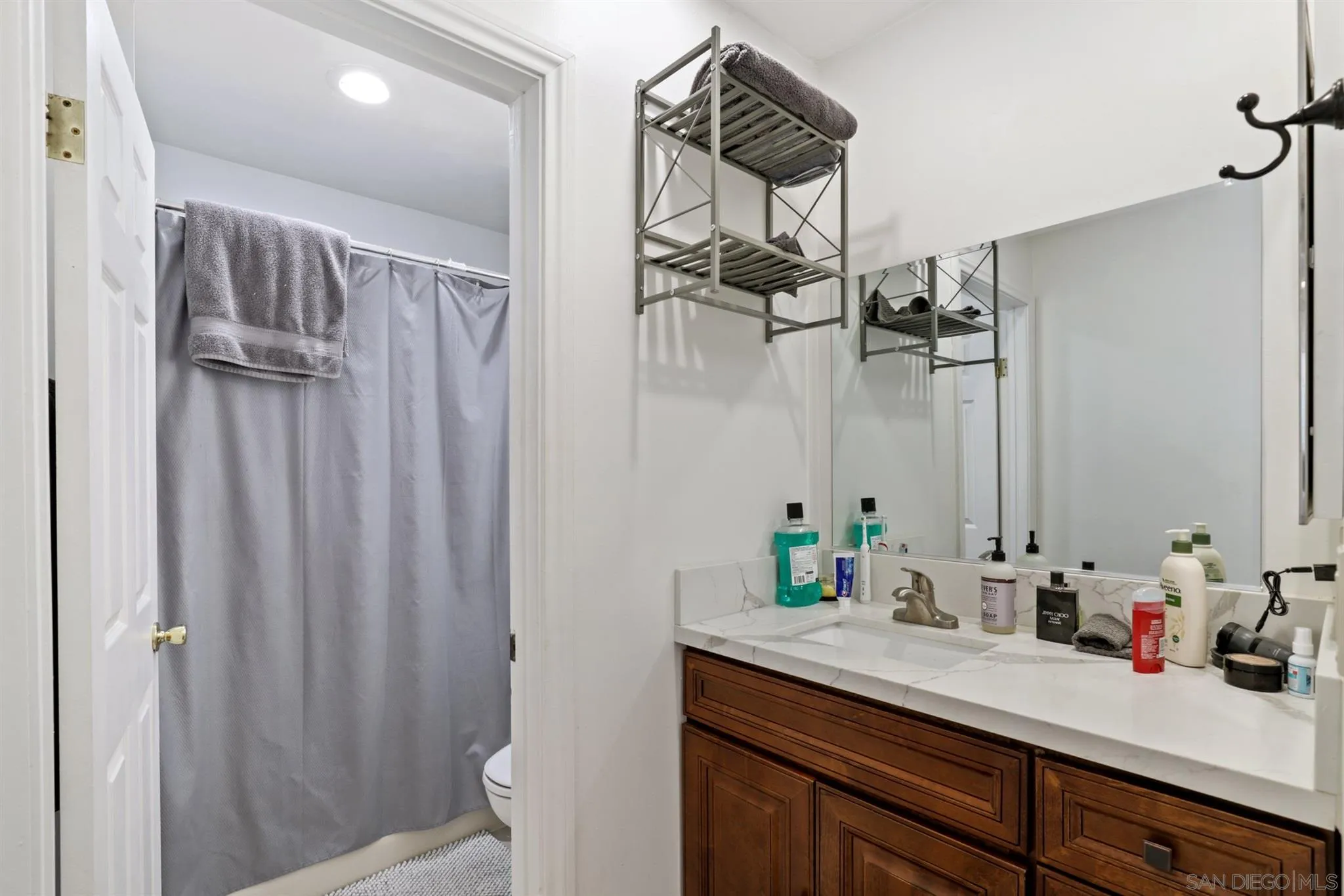 1633 Thomas Avenue San Diego, CA 92109 - Photo 24 of 48 a bathroom with a sink a toilet and shower curtain